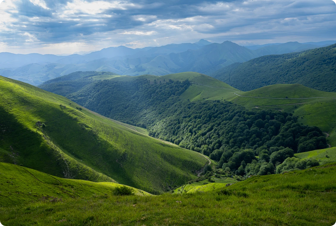 Lush green hills under cloudy sky